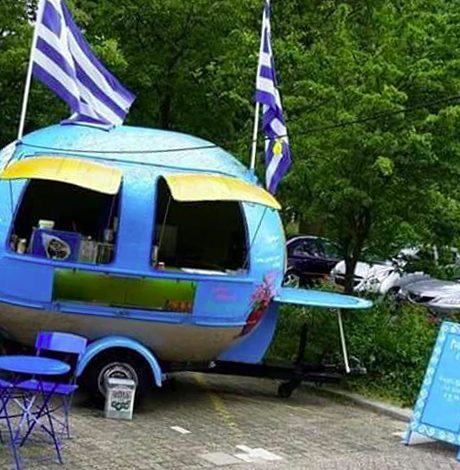 De blauwe foodtruck van De Griekse Olijf met Griekse vlaggen